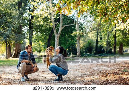 Stock Photography - Couple with pet dog in park. Fotosearch
