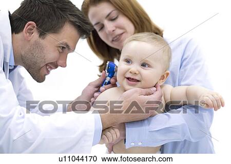 Stock Image - Doctor examining baby boy's ear with otoscope.. Fotosearch