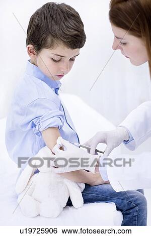 Doctor giving boy injection in arm. View Large Photo Image Stock Photograph - Doctor giving boy injection in arm.. Fotosearch