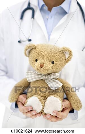 Doctor holding teddy bear. View Large Photo Image Picture - Doctor holding teddy bear.. Fotosearch