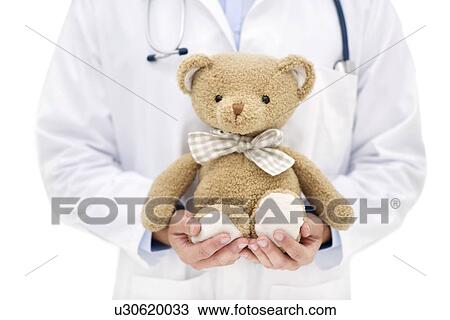 Doctor holding teddy bear. View Large Photo Image Stock Image - Doctor holding teddy bear.. Fotosearch