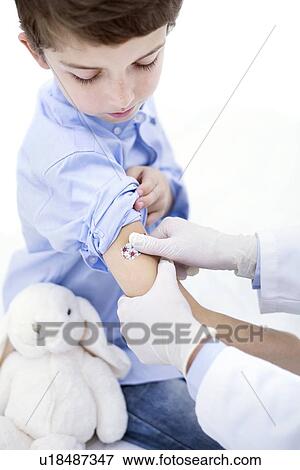 Doctor putting plaster on boy's arm. View Large Photo Image Stock Photo - Doctor putting plaster on boy's arm.. Fotosearch