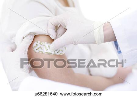 Doctor sticking plaster on young girl's arm after injection View Large Photo Image Stock Image - Doctor sticking plaster on young girl's arm after injection. Fotosearch