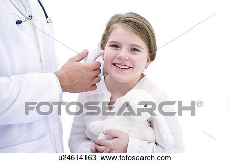 Stock Image - Doctor taking girl's temperature using digital thermometer. Fotosearch