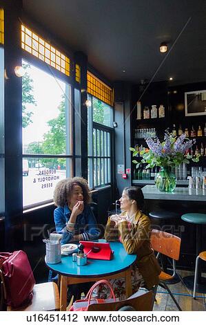 Stock Image - Friends in cafe, London, UK. Fotosearch