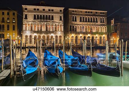 Stock Photograph - Gondolas on Grand canal waterfront at night, Venice, Veneto, Italy. Fotosearch