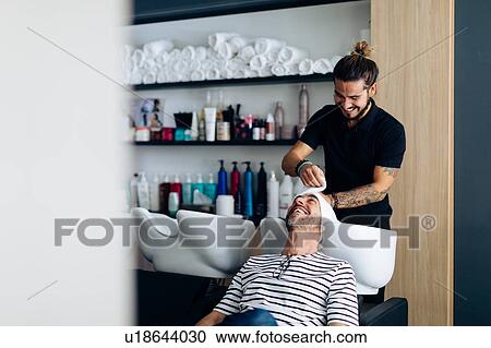 Male hairstylist putting towel on male customer's hair in hair salon View Large Photo Image Stock Image - Male hairstylist putting towel on male customer's hair in hair salon. Fotosearch