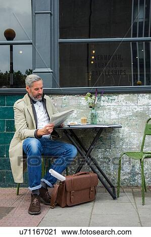 Man reading papers at pavement cafe, London, UK View Large Photo Image Stock Image - Man reading papers at pavement cafe, London, UK. Fotosearch
