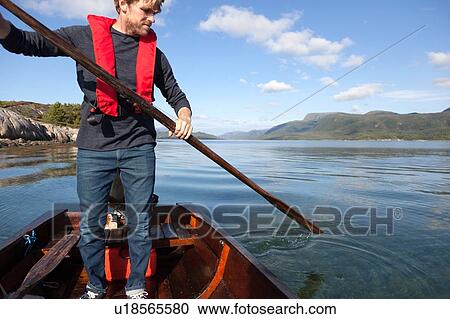 Mature man standing up to use oar in rowing boat, Aure, More og Romsdal, Norway View Large Photo Image Stock Image - Mature man standing up to use oar in rowing boat, Aure, More og Romsdal, Norway. Fotosearch