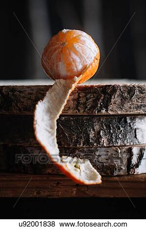 Part peeled tangerine on rustic cutting board View Large Photo Image Stock Photo - Part peeled tangerine on rustic cutting board. Fotosearch