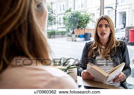 Pregnant mid adult woman discussing book with her friend in cafe View Large Photo Image Stock Image - Pregnant mid adult woman discussing book with her friend in cafe. Fotosearch