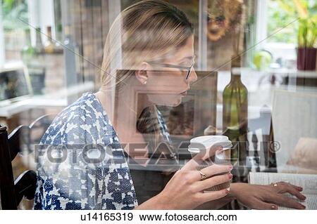 Pregnant mid adult woman reading a book at kitchen table View Large Photo Image Stock Photo - Pregnant mid adult woman reading a book at kitchen table. Fotosearch