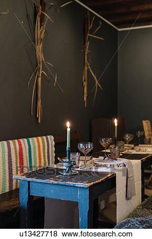 Stock Photo - Prepared tables with lit candles in rustic restaurant. Fotosearch