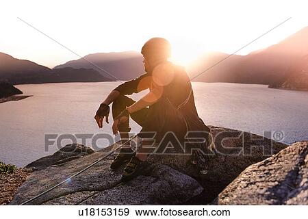 Stock Photo - Rock climber enjoying sunset on Malamute, Squamish, Canada. Fotosearch