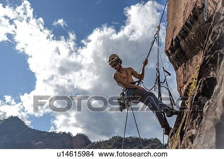 Picture - Rock climber scaling rock face, Liming, Yunnan, China. Fotosearch