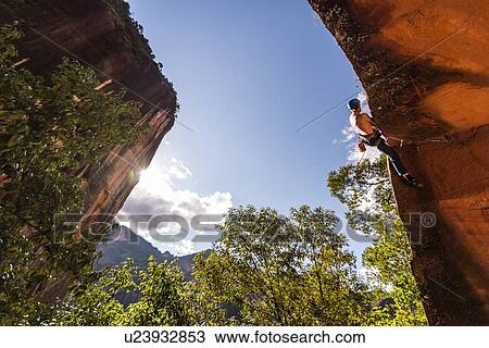 Stock Image - Rock climber scaling rock face, Liming, Yunnan, China. Fotosearch