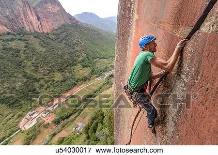 Rock climber scaling rock face, Liming, Yunnan, China View Large Photo Image Stock Photo - Rock climber scaling rock face, Liming, Yunnan, China. Fotosearch