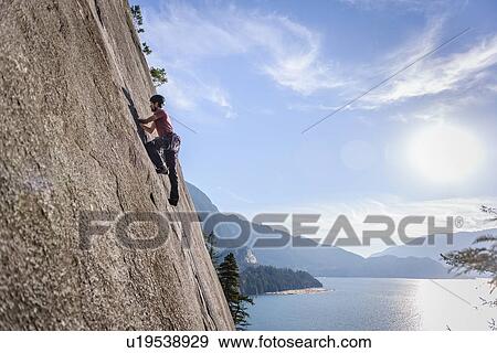 Stock Photo - Rock climber scaling rock on Malamute, Squamish, Canada. Fotosearch