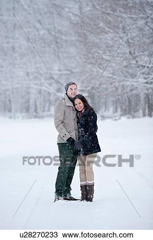 Stock Image - Romantic young couple in snow covered forest, portrait, Ontario, Canada. Fotosearch