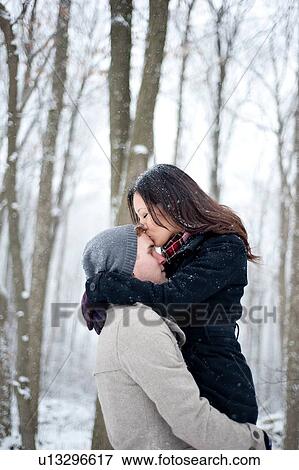 Romantic young woman kissing boyfriend's forehead in snow covered forest, Ontario, Canada View Large Photo Image Stock Photo - Romantic young woman kissing boyfriend's forehead in snow covered forest, Ontario, Canada. Fotosearch