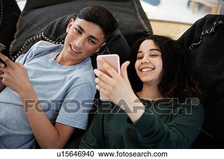 School friends lying on beanbags and texting at school View Large Photo Image Stock Image - School friends lying on beanbags and texting at school. Fotosearch