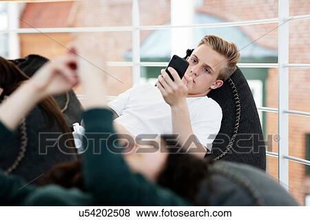 School friends lying on beanbags and texting at school View Large Photo Image Stock Photo - School friends lying on beanbags and texting at school. Fotosearch