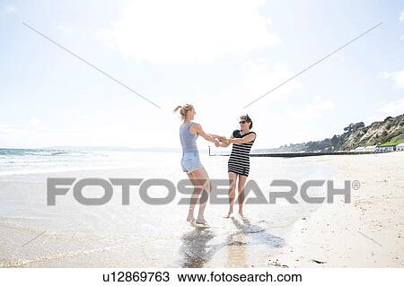 Sisters enjoying themselves on beach View Large Photo Image Stock Image - Sisters enjoying themselves on beach. Fotosearch