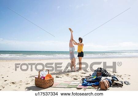 Picture - Sisters enjoying yoga on beach. Fotosearch