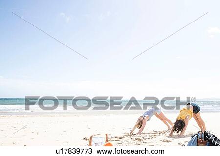 Sisters enjoying yoga on beach View Large Photo Image Stock Image - Sisters enjoying yoga on beach. Fotosearch