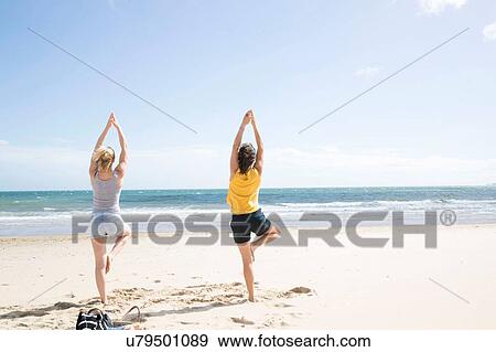 Sisters enjoying yoga on beach View Large Photo Image Stock Photo - Sisters enjoying yoga on beach. Fotosearch