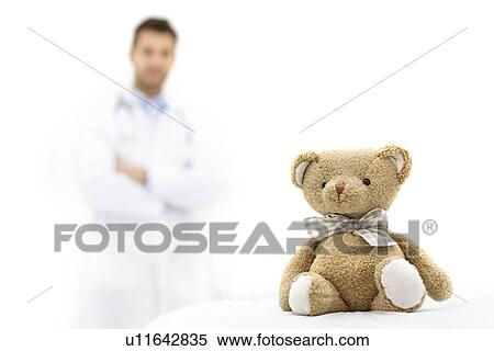 Stock Photography - Teddy bear with male doctor in background.. Fotosearch