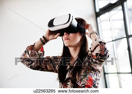 Teenage girl looking through virtual reality handset View Large Photo Image Stock Photography - Teenage girl looking through virtual reality handset. Fotosearch