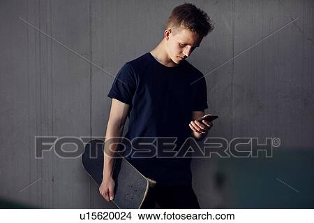 Teenage skateboarder texting View Large Photo Image Picture - Teenage skateboarder texting. Fotosearch