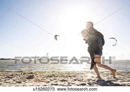 Stock Image - Twin brother and sister playing on beach. Fotosearch