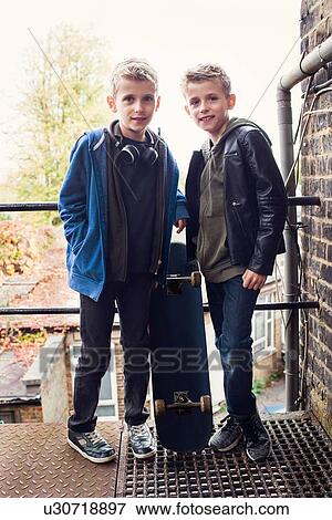 Stock Photo - Twins posing with skateboard. Fotosearch