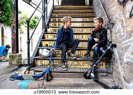 Twins talking on metal staircase View Large Photo Image Stock Image - Twins talking on metal staircase. Fotosearch