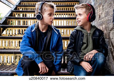 Stock Photo - Twins talking on metal staircase. Fotosearch