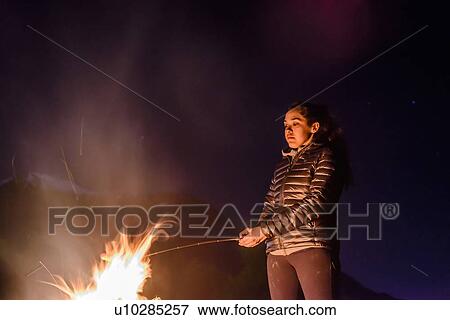 Stock Photo - Woman grilling on barbecue, Nexen Beach, Squamish, Canada. Fotosearch