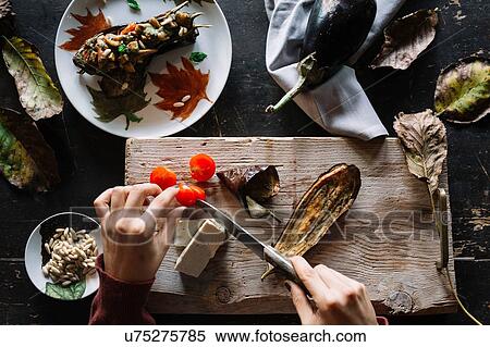 Woman slicing cherry tomatoes on rustic chopping board, overhead view of hands View Large Photo Image Stock Photography - Woman slicing cherry tomatoes on rustic chopping board, overhead view of hands. Fotosearch