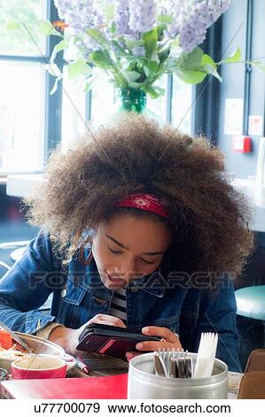 Woman using cellphone in cafe, London, UK View Large Photo Image Stock Photo - Woman using cellphone in cafe, London, UK. Fotosearch
