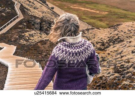 Picture - Woman walking around Grabrok volcano, Iceland. Fotosearch