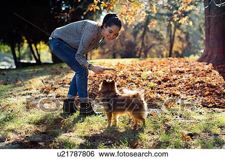 Stock Photograph - Woman with pet dog in park. Fotosearch