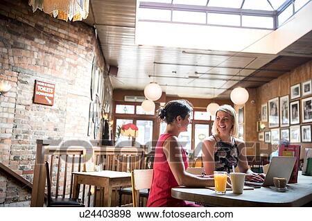 Stock Photo - Women brainstorming business ideas in restaurant. Fotosearch