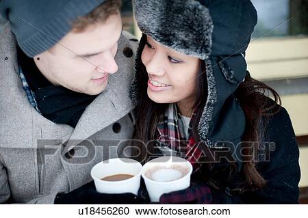 Young couple in winter hats having takeaway drinks View Large Photo Image Stock Image - Young couple in winter hats having takeaway drinks. Fotosearch