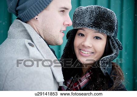 Stock Image - Young couple in winter hats, head and shoulder portrait. Fotosearch