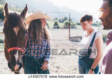 Young cowgirl with horse in rural equestrian arena View Large Photo Image Stock Photo - Young cowgirl with horse in rural equestrian arena. Fotosearch