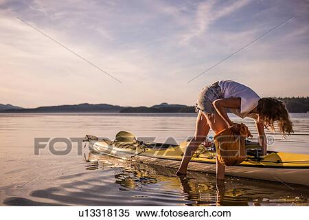 Stock Photography - Young female kayaker unpacking kayak, Quadra Island, Campbell River, Canada. Fotosearch