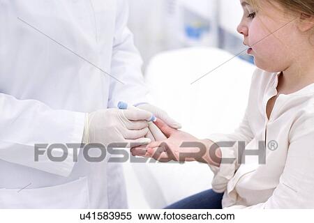 Stock Photography - Young girl having finger prick test.. Fotosearch