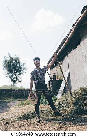 Stock Photo - Young male agricultural worker with pitchfork, full length portrait. Fotosearch