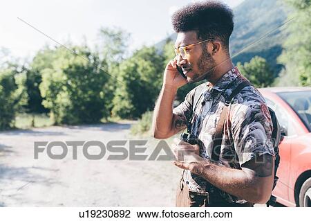 Young male hiker on rural dirt track making smartphone call, Primaluna, Trentino-Alto Adige, Italy View Large Photo Image Stock Image - Young male hiker on rural dirt track making smartphone call, Primaluna, Trentino-Alto Adige, Italy. Fotosearch